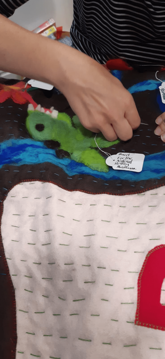 The map, including a felted dinosaur, being quilted