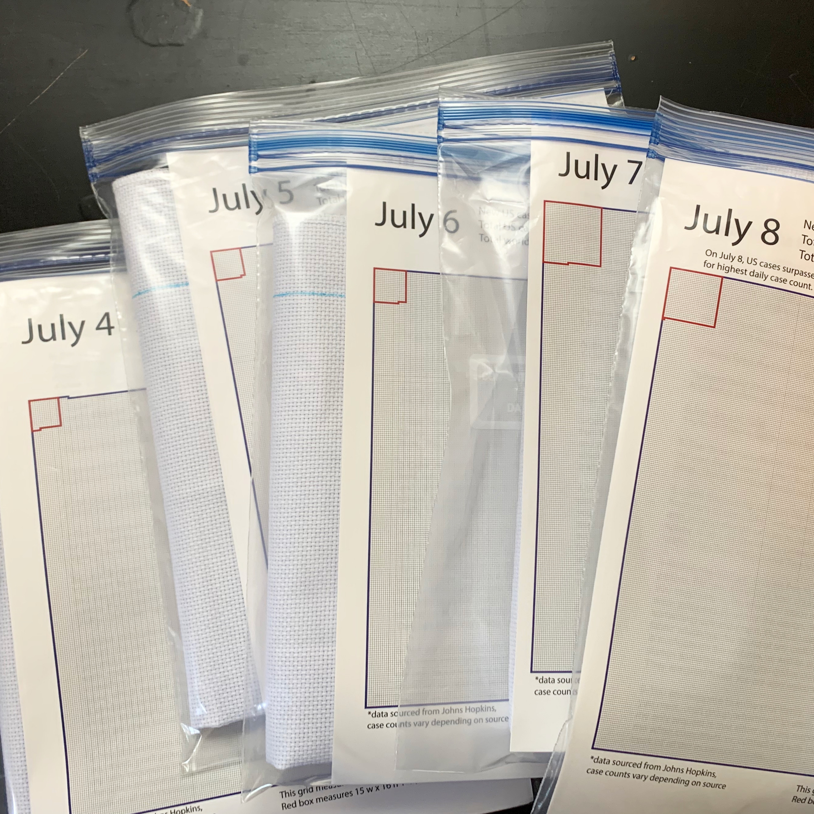 embroidery packs in plastic wallets, each with a different date in July.