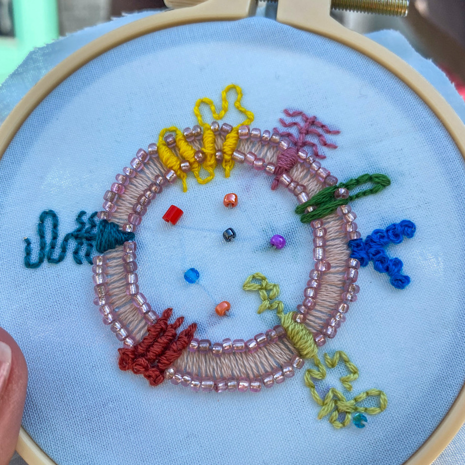 embroidered circle with various different shapes straddling the outline